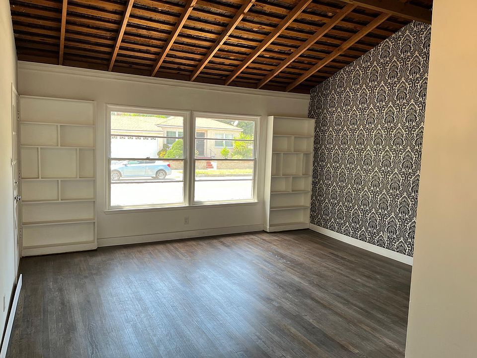 Amazing living room with built in bookshelves and beamed ceilings. New windows going in here this week!