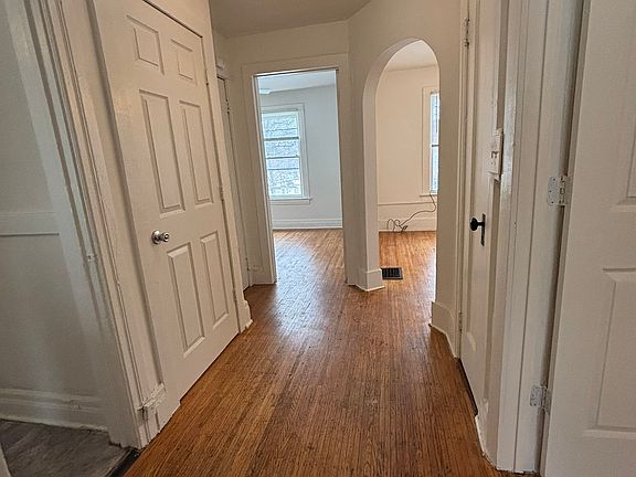 That's the front door on the left. Going clockwise is bedroom 1, then living room with arched doorway, small hall closet, bedroom 2 (the opened door on the right in photo), then bathroom (where camera is currently positioned), and then kitchen (left)