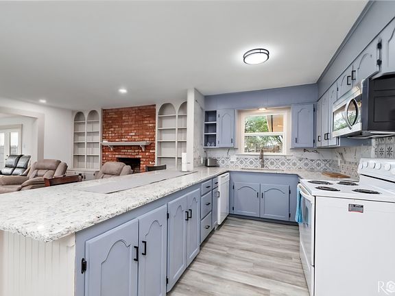 Kitchen with dishwasher, electric stove, microwave and granite counter top