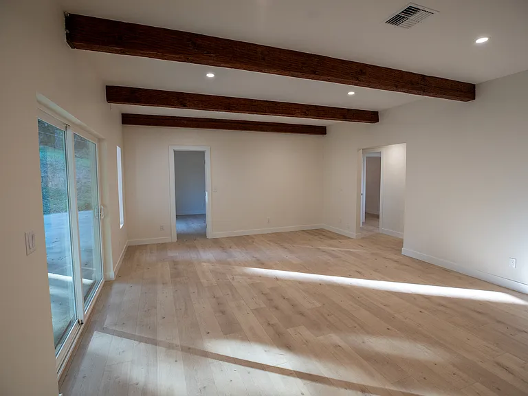New sliding door leads to exterior back patio, hallway to two additional bedrooms and third bedroom.