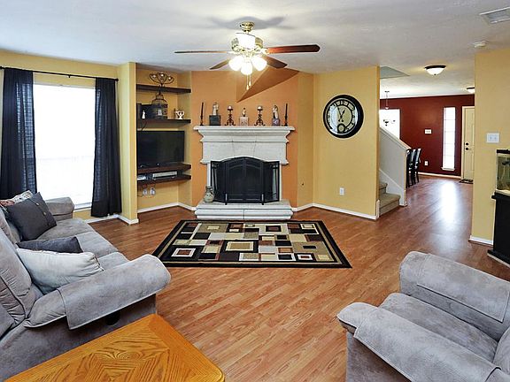 DEN / FAMILY ROOM - Corner fireplace, windows overlooking the side yard and ceiling fan accentuates 