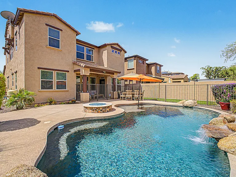 Enjoy the beautifully landscaped backyard featuring a sparkling pool, a cozy gas fireplace, a small turf area, and a spacious patio - perfect for relaxing, entertaining, or spending time with family and friends.