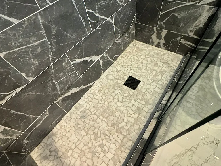 Guest bathroom with high glass, all tile and niche.