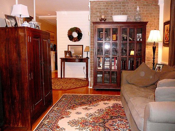 Living Room w/hardwood floor, wainscotting, chair rail, crown moulding & fan.