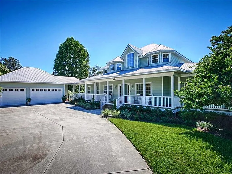 This is a driveway level view of the front of the house, with its wrap around porches and three car garage. The central gable is the top of the two story foyer and the upper windows are off the craft rooms.