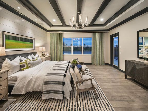 Primary bedroom offers a beautiful tray ceiling with private entry to the outdoor living space