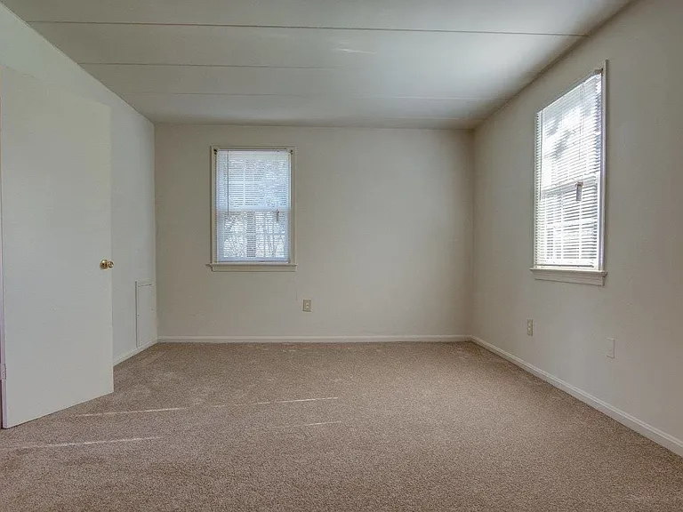 Large bedroom with high ceilings and two large windows
