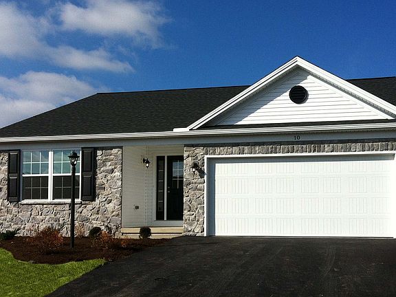 Exterior front view of the Elmcrest ranch with full stone front and two car garage - by S A Homes