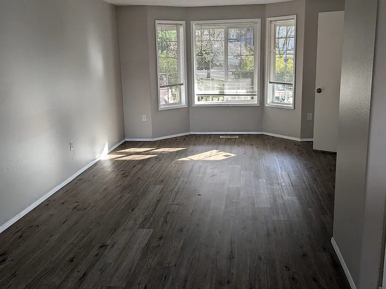 Living room view window facing front porch with new Luxury Vinyl Flooring