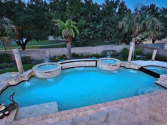 The pool features a spa to the right with multiple fountains in the back.