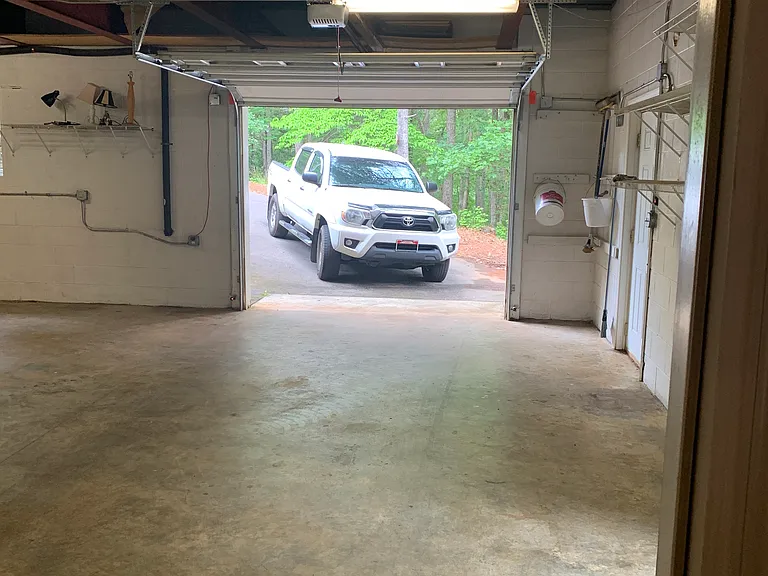 Attached garage with garage door opener, and access door to patio. Paved gently sloping drive all the way in.