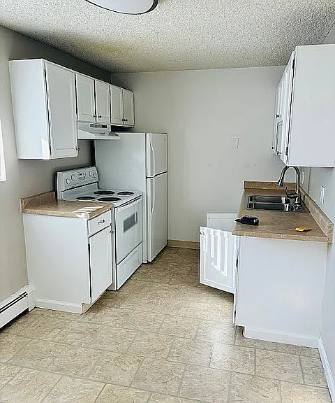 Charming and efficient kitchen with white cabinetry, modern appliances, and ample countertop space.