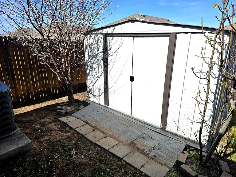 Outdoor storage shed provides additional space for tools and equipment.