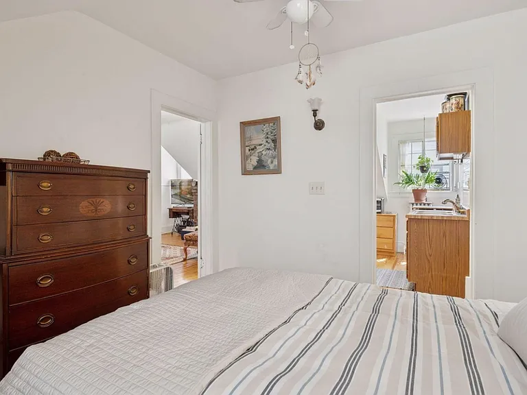 Second angle of bedroom showing doorways to kitchen (+ bathroom) and living space. Plenty of natural light year-round.