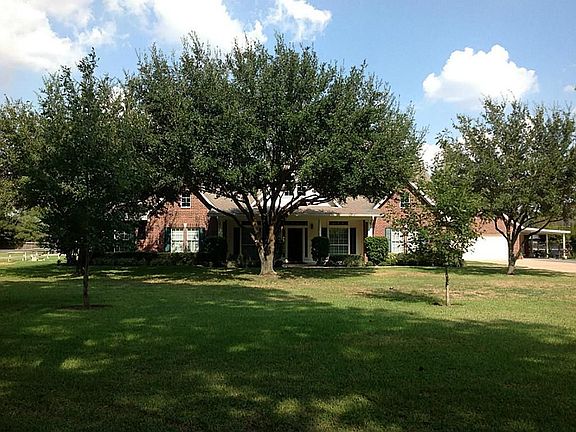 Front view of the home with its beautiful live oaks that provide excellent shade. What a wonderful place for family gatherings!