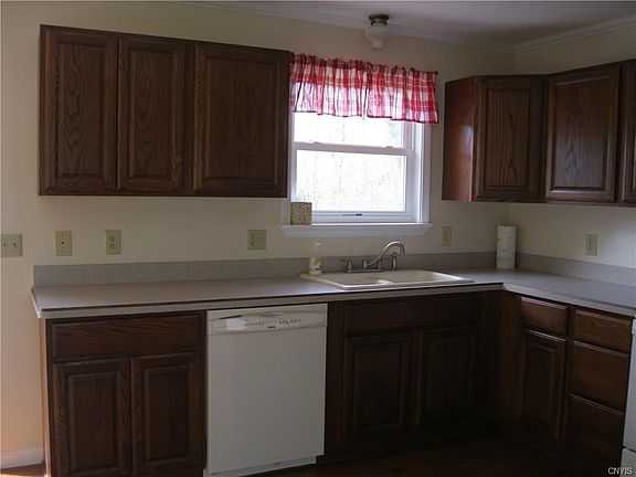 Kitchen Window overlooks large backyard with in-ground pool