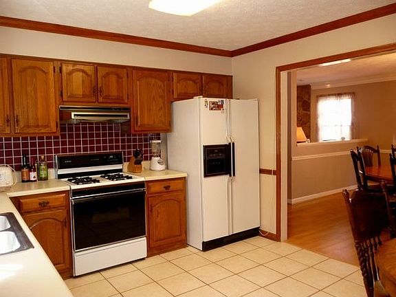 Kitchen with stained cabinets and tile floor.