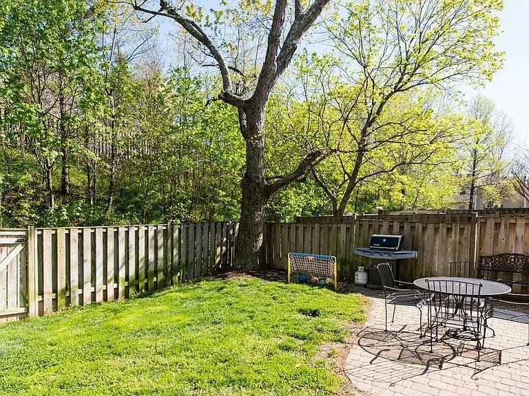 Extended backyard with brick patio, shed, veggie bed, backs to trees (two gates, front and back)