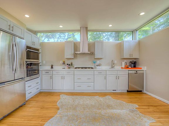 Recently renovated kitchen with gas range, outside venting hood, dishwasher, double oven and french door refrigerator