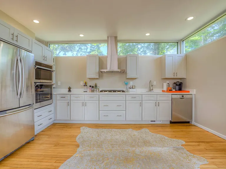 Recently renovated kitchen with gas range, outside venting hood, dishwasher, double oven and french door refrigerator