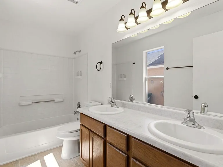 Master bathroom has two sinks with bathtub