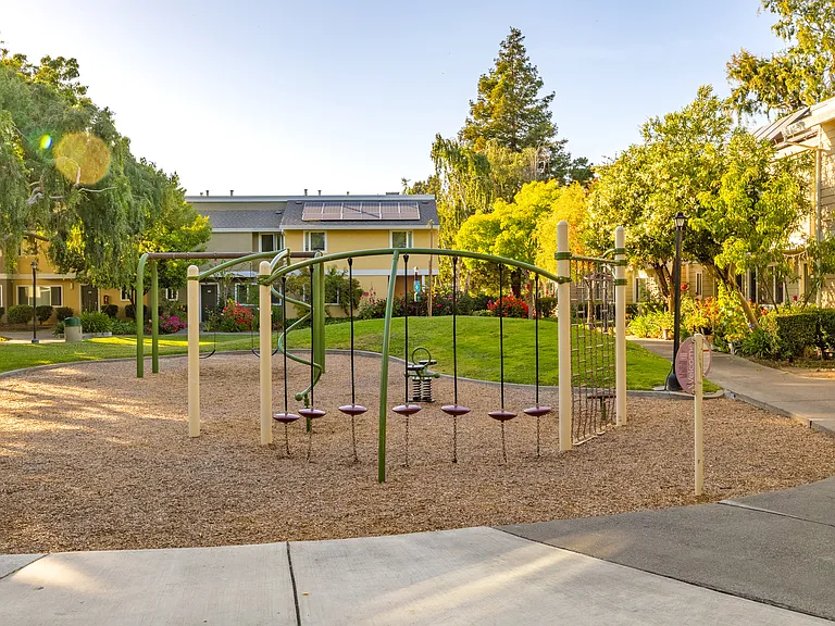 Vibrant play area surrounded by greenery offers the perfect space for kids to laugh, climb, and explore.