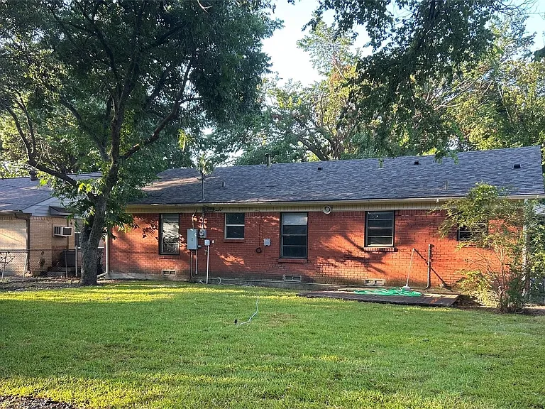 Expansive green lawn with mature trees bordering the property