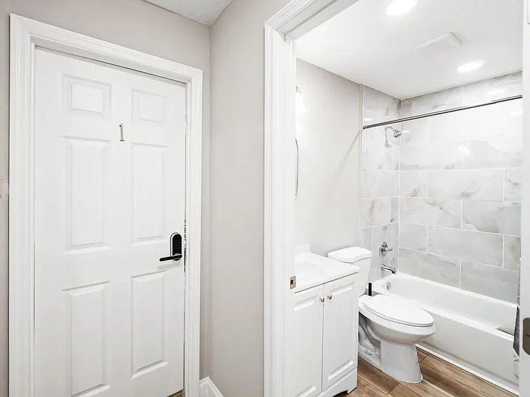 Full bathroom with a tub/shower combo, tiled surround, and a vanity with under-sink storage for daily essentials.