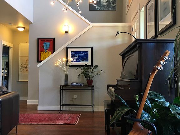 Open, 2 story foyer, loads of lights. Looking from the living room looking into foyer and stairs to second floor.
