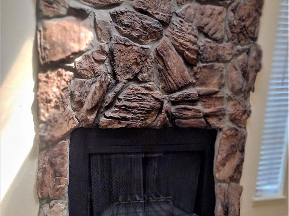 Chimney with stones and beautifully decorated tile.