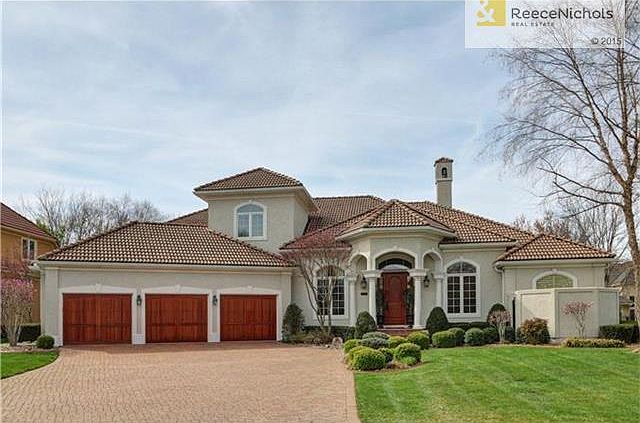 Stunning from front to back..paver drive, custom solid wood garage doors and front door
