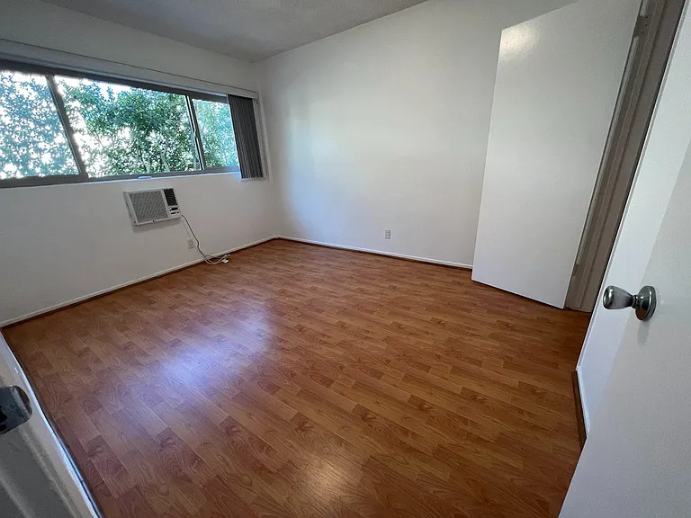 Second bedroom / home office with: walk-in wardrobe, wall-mounted aircon, and lovely aspect onto green mature garden.