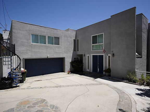 This three-level residence offers six bedrooms in total, with three located upstairs and three downstairs. The main floor includes the kitchen, living room, and dining area, and features two kitchens _ a spacious main kitchen and a secondary kitchenette