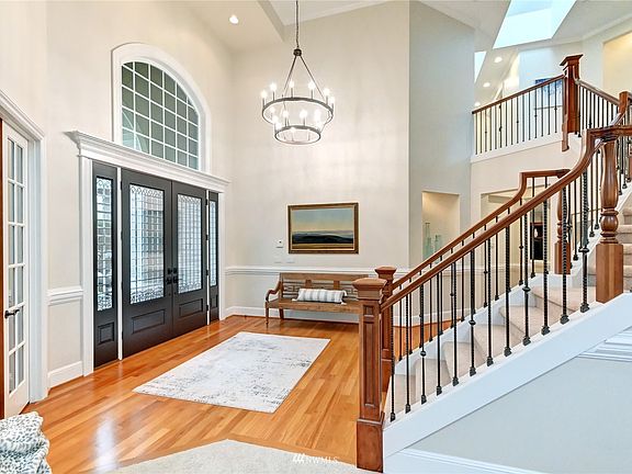 Gorgeous new chandelier is in keeping with the stunning black front door and wrought iron balusters.