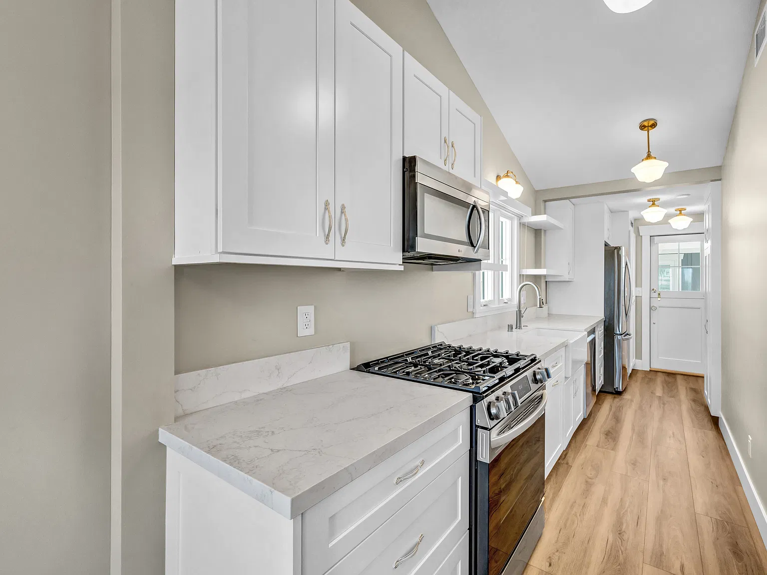 Kitchen | Beautiful quartz countertops, a farmhouse sink, stylish finishes, soft-close drawers, and plenty of cabinet space.