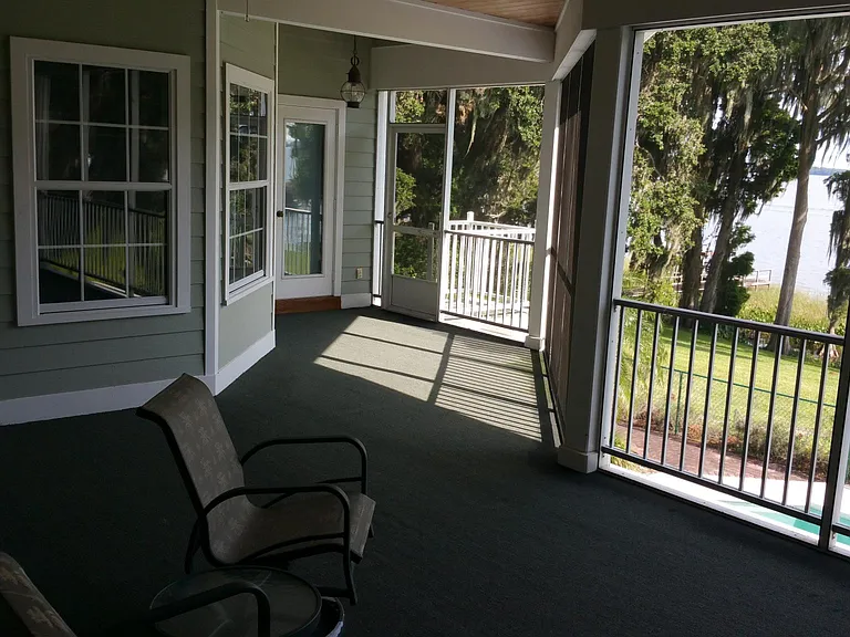 NOTE: the floor of this main screened in porch has been replaced with beautiful decking. The windows to the left are from the breakfast nook and the door leads into the family room. far left is a pass through window to the kitchen