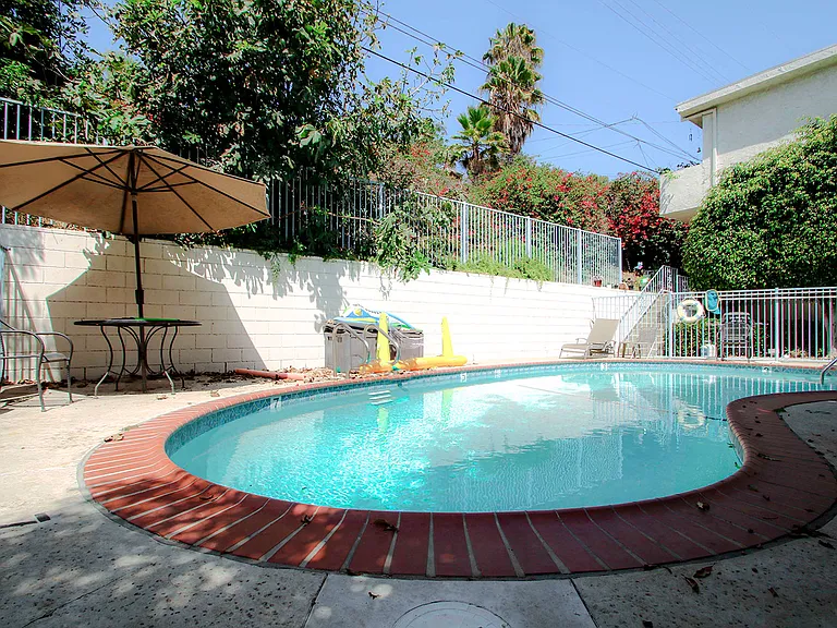 Gated swimming pool with seating area.