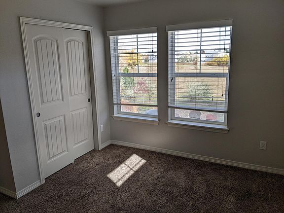 Bedroom for rent with closet. Parking in back is visible through this East window.