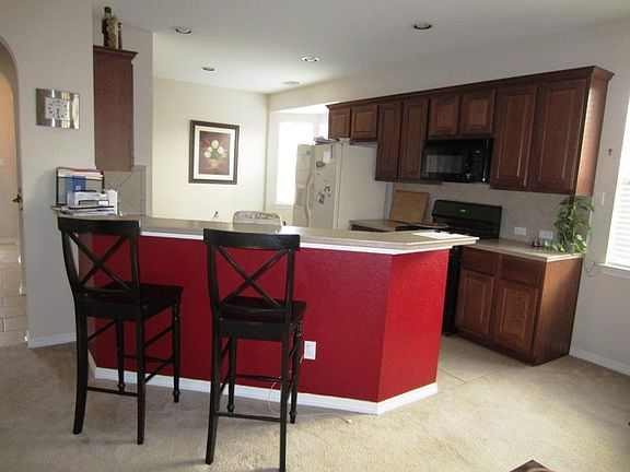Kitchen has breakfast bar. Door to formal dining.