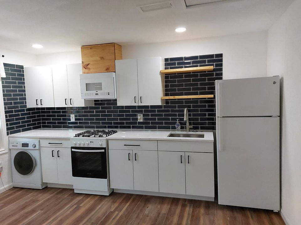 New cabs, quartz counter, deep stainless sink, garbage disposal, range, micro, washer/dryer, subway-tiled backsplash, floating shelves