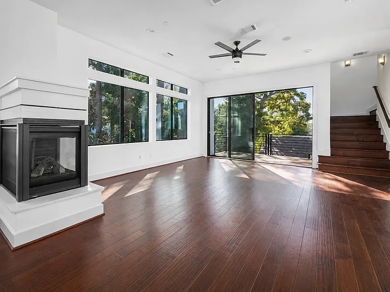 Open living room area with tall sliding glass doors that open to a balcony