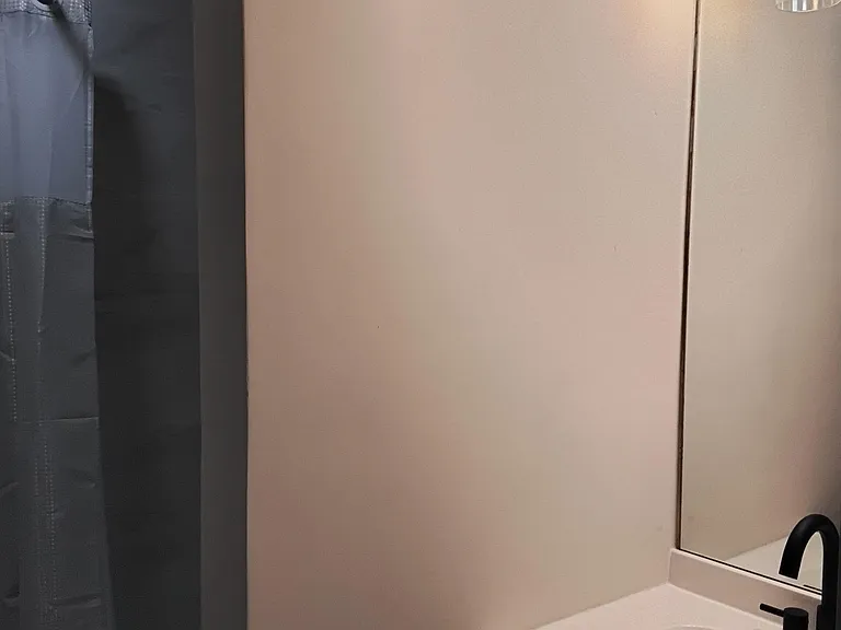 Bathroom with a tub/shower combo, vanity with undermount sink, and wall mirror with overhead lighting.
