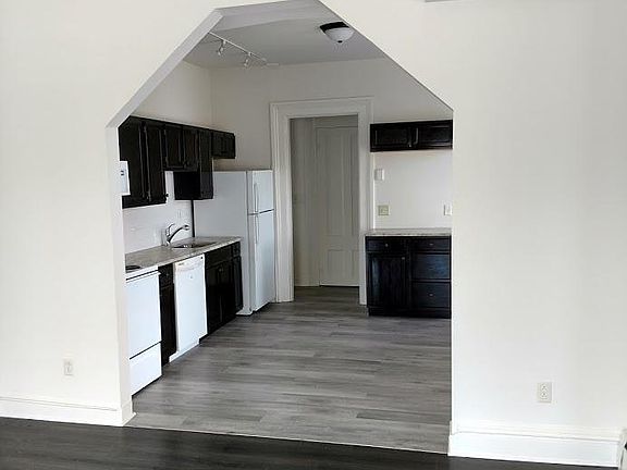 standing in living room looking into kitchen. notice air conditioner built into wall