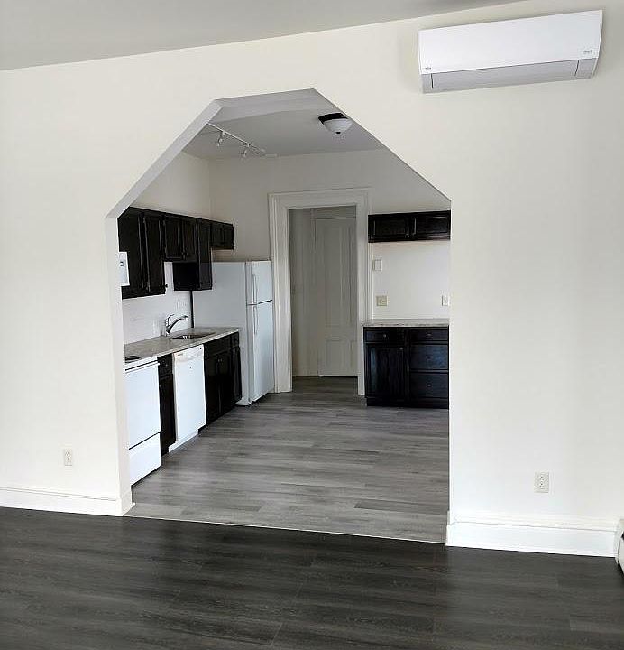 standing in living room looking into kitchen. notice air conditioner built into wall