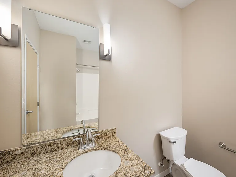 Elegant bathroom with a granite countertop sink, modern lighting, and a sleek design. Elegant bathroom with a granite countertop sink, modern lighting, and a sleek design.