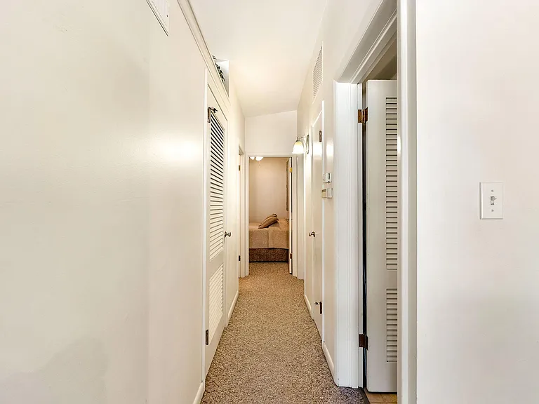 Hallway leading to laundry room and bedrooms/bathrooms