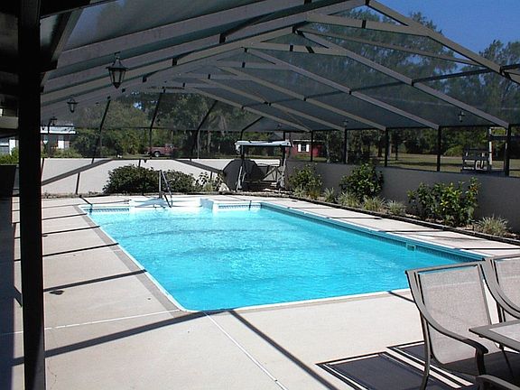 Large screened in pool with sitting area.