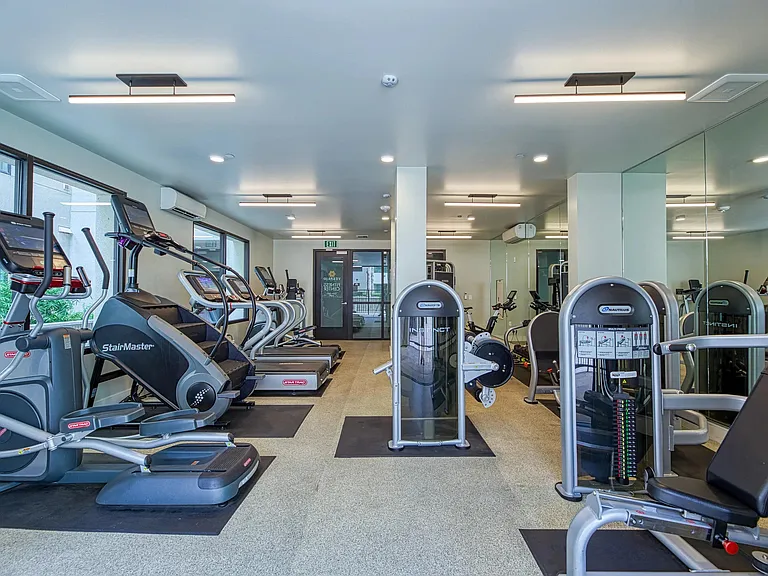 Fitness center with cardio machines, strength stations, and direct access to the pool deck.