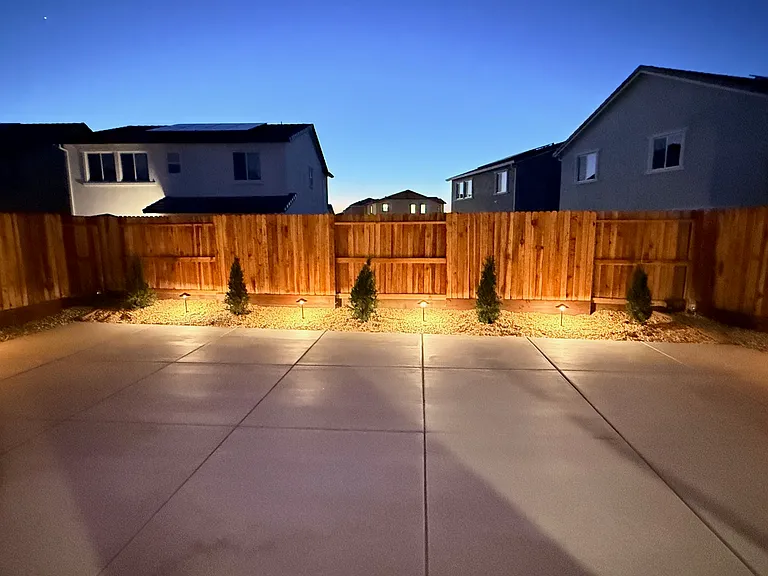 Professional landscaping with outdoor lighting that provides a relaxing amount of light, making it easy to navigate and enjoy the backyard in the evenings