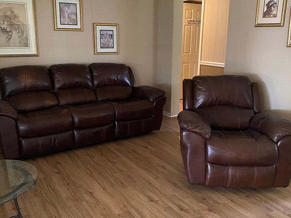 Living Room with brown leather sofa with 2 recliners, and matching brown leather recliner chair.